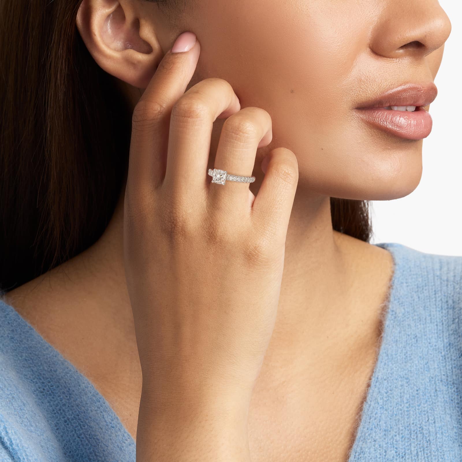 GIA 5.00 carat cushion diamond engagement ring on a woman's hand, highlighting the French pavé platinum band and the magnificent center stone.