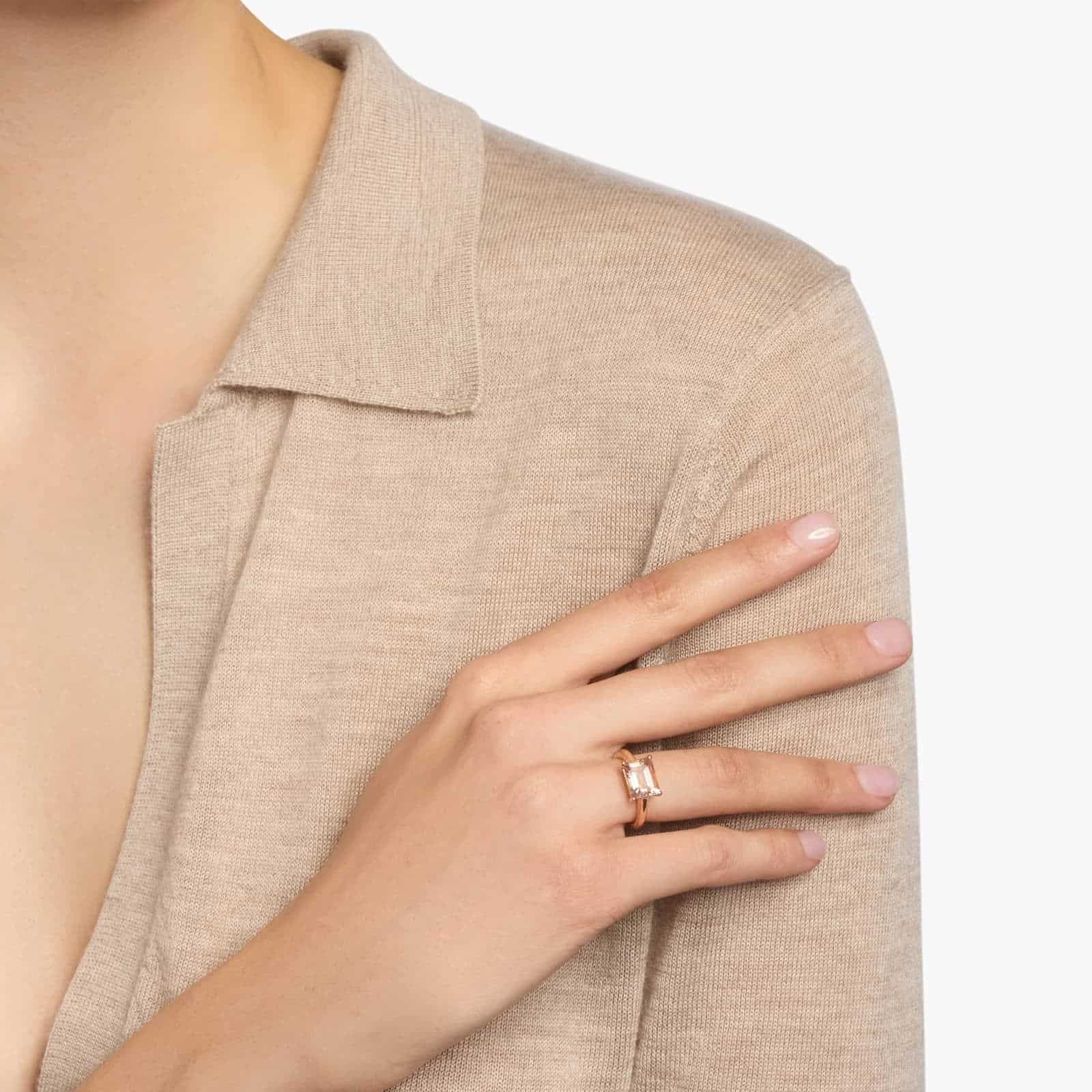 Morganite East West Ring in 14k Rose Gold 3 A woman's hand wearing an **east west Morganite Engagement Ring**, showcasing the unique horizontal setting of the emerald-cut gemstone in 14K rose gold.