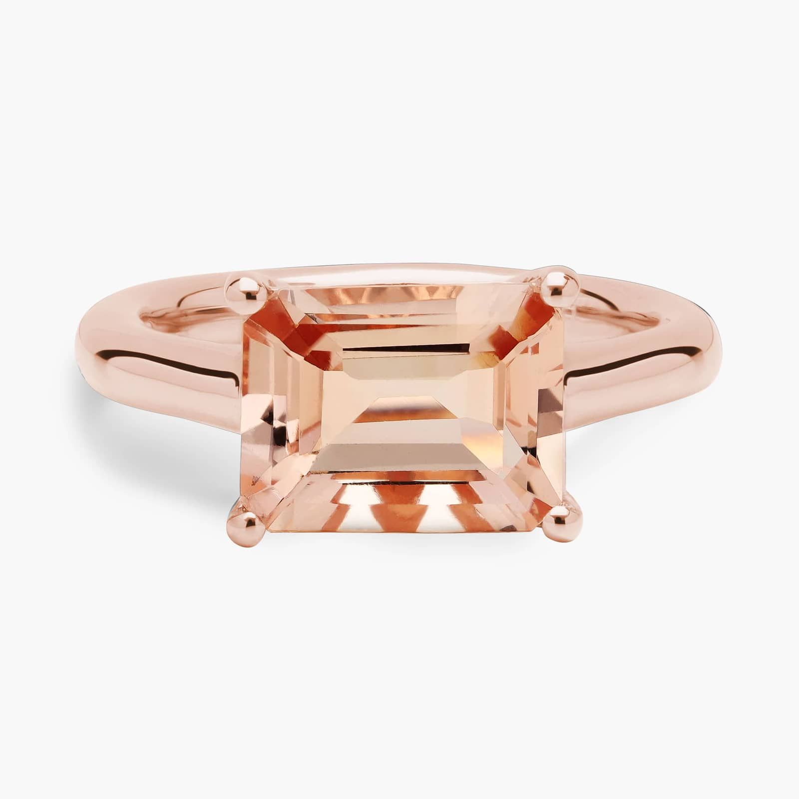 Morganite East West Ring in 14k Rose Gold A professional studio image of an **east west morganite ring** on a white background, highlighting the sleek lines of the emerald cut and the elegant 14K rose gold prong setting.