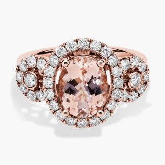 A close-up studio shot of an **oval morganite and diamond ring** on a white background, highlighting the central stone, the bezel-set diamonds, and the intricate pavé detail on the band.