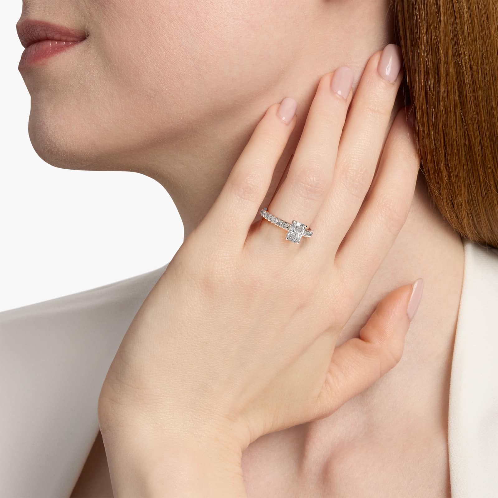 A woman's hand wearing a luxurious 3 carat radiant cut diamond ring with a French Pavé band in platinum.
