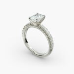 A close-up studio shot of a 3ct radiant cut diamond ring, highlighting the G-VVS2 clarity of the center stone and the intricate pavé setting.