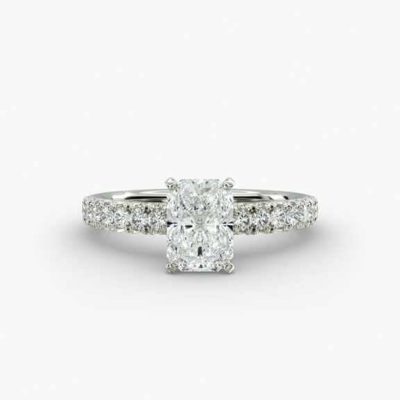 A close-up studio shot of a 3ct radiant cut diamond ring, highlighting the G-VVS2 clarity of the center stone and the intricate pavé setting.