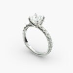 A close-up studio shot of a **7 carat diamond ring**, highlighting the sharp corners of the Princess cut diamond and the delicate detail of the French pavé side stones.