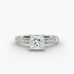 A close-up side view of a 2 carat princess cut diamond engagement ring, highlighting the F-VVS1 clarity of the center stone and the detailed French pavé setting.