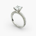 A close-up side view of a 2 carat princess cut diamond engagement ring, highlighting the F-VVS1 clarity of the center stone and the detailed French pavé setting.