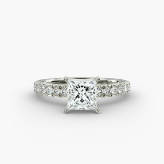 A close-up side view of a 2 carat princess cut diamond engagement ring, highlighting the F-VVS1 clarity of the center stone and the detailed French pavé setting.