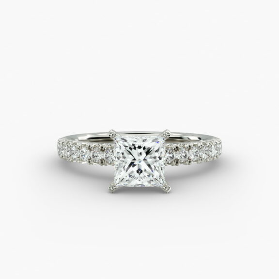 A close-up side view of a 2 carat princess cut diamond engagement ring, highlighting the F-VVS1 clarity of the center stone and the detailed French pavé setting.