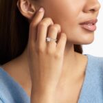 A woman's hand wearing a stunning 2 carat princess cut diamond engagement ring with a French pavé band in platinum.