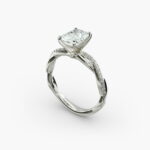 A close-up side view of a 2 carat radiant cut diamond ring, highlighting the F-VS1 clarity of the center stone and the elegant twist setting.