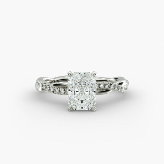 A close-up side view of a 2 carat radiant cut diamond ring, highlighting the F-VS1 clarity of the center stone and the elegant twist setting.