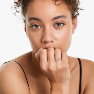 A woman's hand wearing a large marquise diamond ring with baguettes, showcasing the 5.00 ct. lab-grown center stone and platinum band.