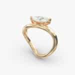 A close-up view of the marquise shaped diamond with prominent claw prongs on the Sculptural Waves yellow gold band.