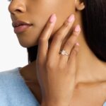 A woman's hand wearing a massive 6 carat radiant cut diamond ring with a G-VS2 lab-grown center stone and a Hidden Halo setting in white gold.