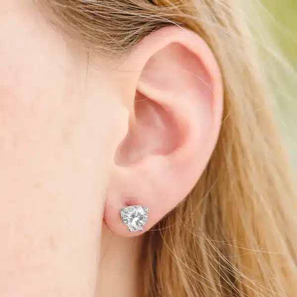 A pair of Heart Four-Prong Basket Stud Earrings featuring 2 CTW DEW Moissanite in 14K White Gold, a brilliant alternative for Luxury Push Present Ideas and a diamond earrings push present model view.