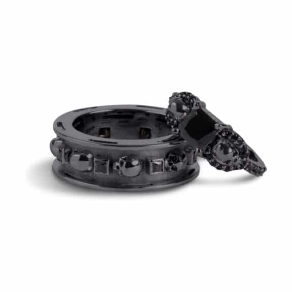 A set of Black Wedding Ring Sets His and Hers featuring a Princess Cut Black Moissanite Skull Engagement Ring and matching wedding band in 925 Sterling Silver with a Gun Metal finish.