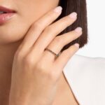 A Riviera Noir Pavé Black Diamond Black Wedding Rings For Women band (1.50mm) in 18K Yellow Gold with 0.50 CTW black diamonds in women hands view.
