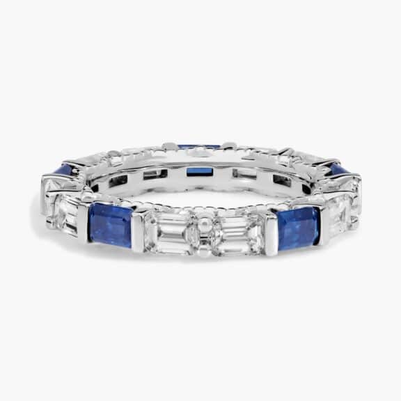 An Alternating East-West Emerald Cut Sapphire and Diamond Blue Wedding Rings For Women band (3.30mm) in 14K White Gold with over 2.5 CTW of stones.