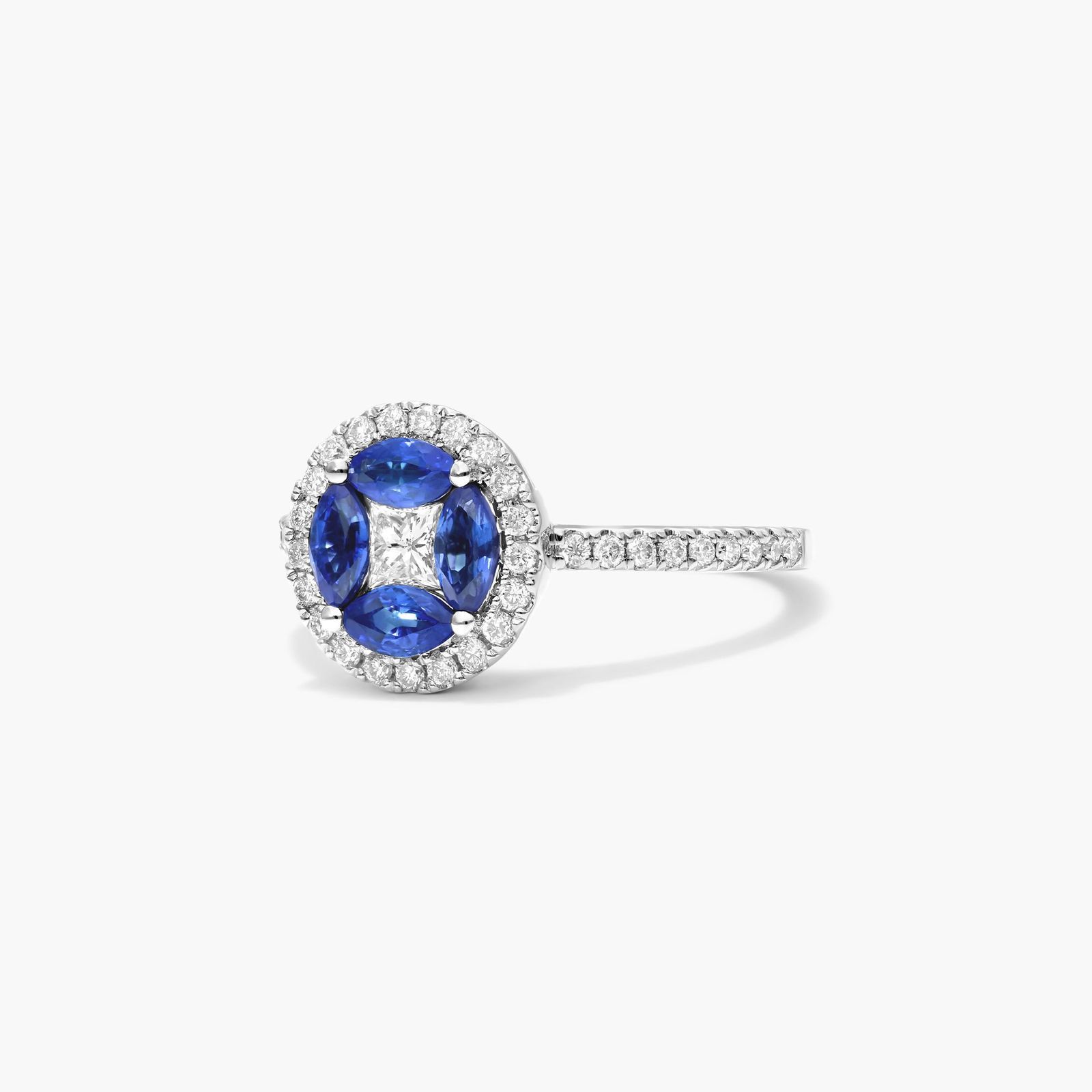 marquise-sapphire-princess-cut-diamond-ring-with-sapphires-14k-white-gold 2 A 14K White Gold Princess Cut Diamond Ring with Sapphires, featuring four Marquise Blue Sapphires (0.62 CT min) set as flower petals, accented by a 0.18 CT Princess Cut Diamond and 0.28 CTW Round Diamonds.