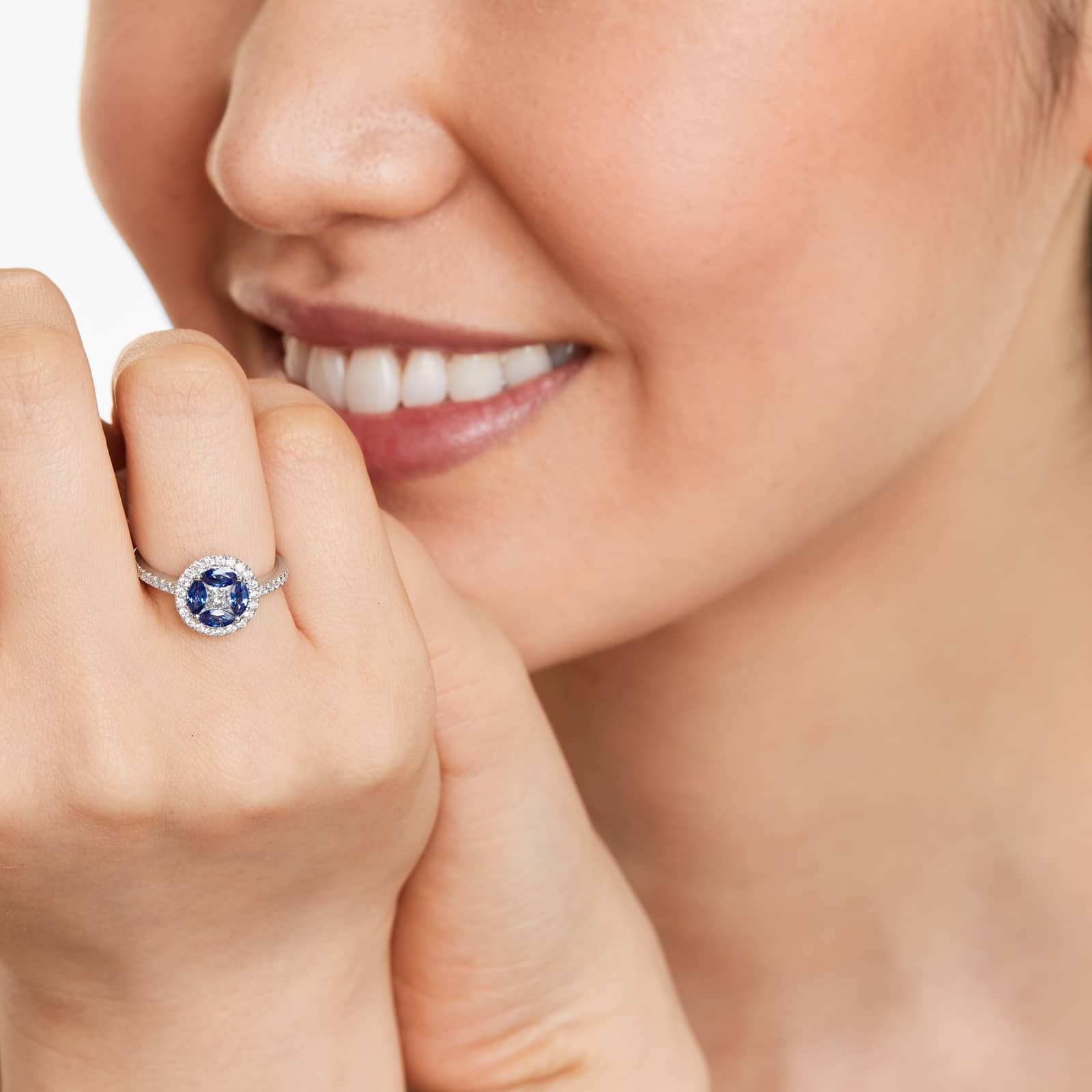 marquise-sapphire-princess-cut-diamond-ring-with-sapphires-14k-white-gold model view 2 A 14K White Gold Princess Cut Diamond Ring with Sapphires, featuring four Marquise Blue Sapphires (0.62 CT min) set as flower petals, accented by a 0.18 CT Princess Cut Diamond and 0.28 CTW Round Diamonds.